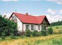 Dom z czerwonym dachem wśród pol